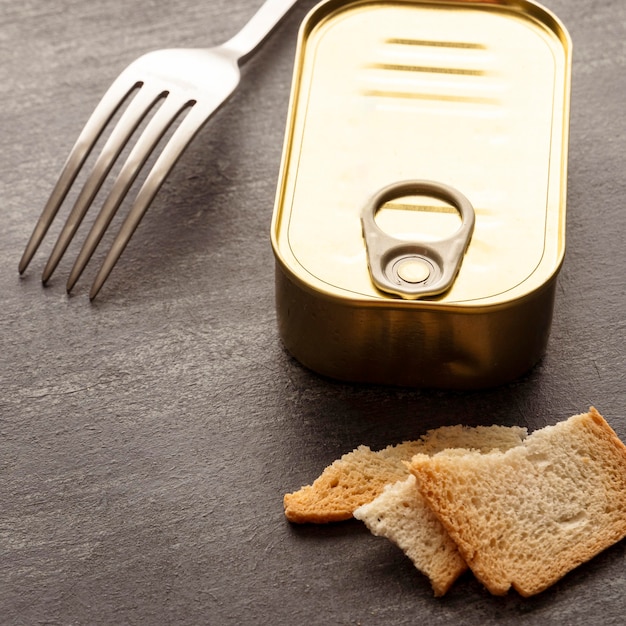 Barattolo di latta ad alto angolo con pane tostato e forchetta