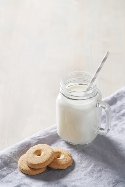 Barattolo di latte e biscotti sulla tavola di legno