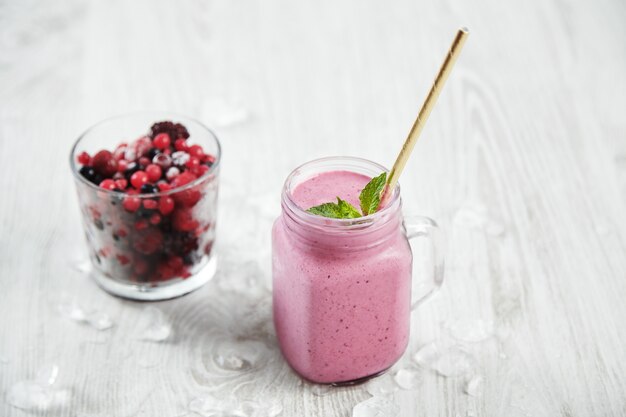 Barattolo rustico trasparente con gustoso frullato viola chiaro appena fatto sano con cannuccia all'interno