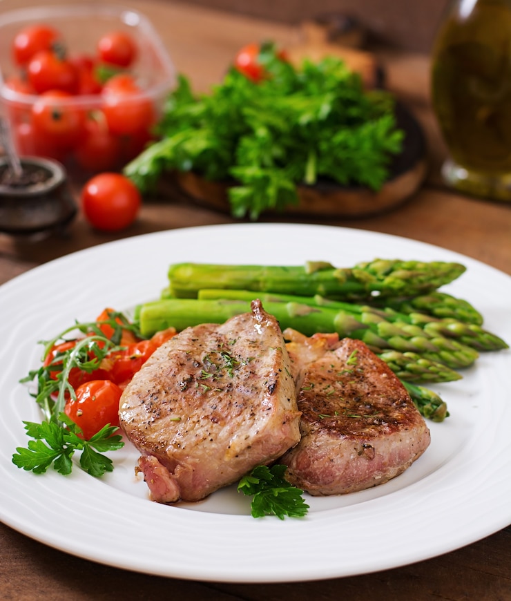 Foto gratuito barbecue bistecca di manzo alla griglia con asparagi e pomodori.