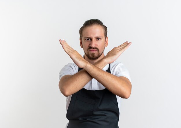 Barbiere bello giovane dispiaciuto che indossa l'uniforme che non gesturing isolato su fondo bianco con lo spazio della copia