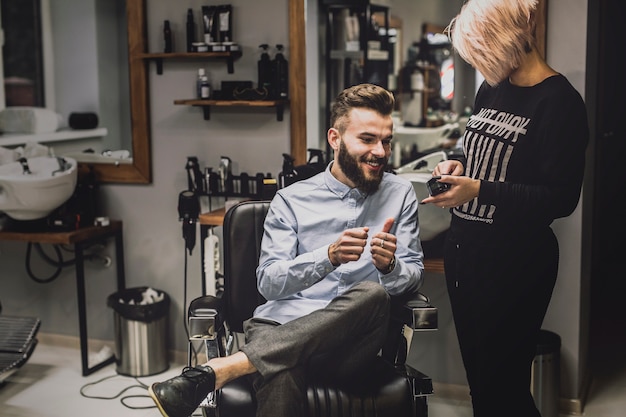 Barbiere che mostra i cosmetici al cliente