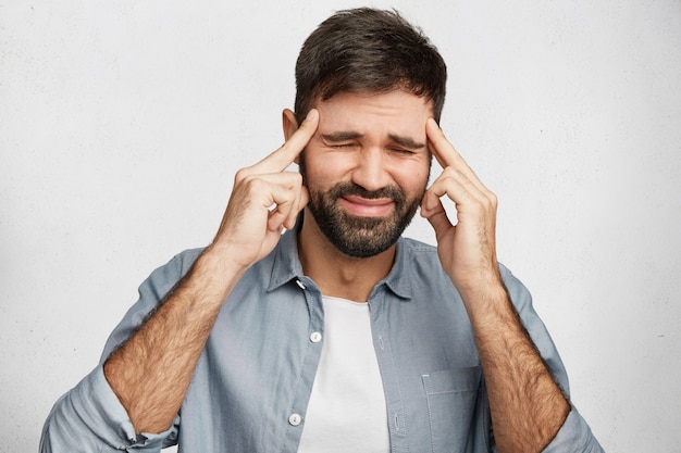 Barbuto giovane uomo che indossa la camicia