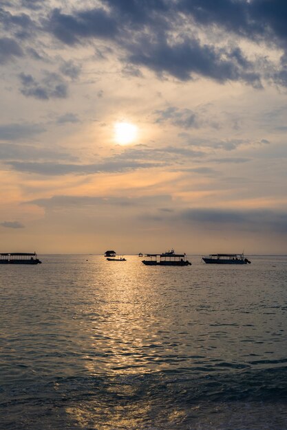 Barca in acqua al tramonto, oceano, sfondo.