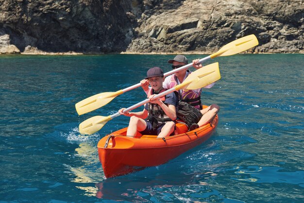 Barca in kayak vicino a scogliere in una giornata di sole. Kayak in una baia tranquilla. Viste incredibili. Viaggi, concetto di sport. Stile di vita. Una famiglia felice.