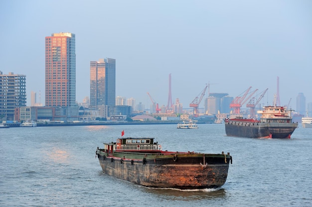 Barca nel fiume Huangpu con architettura urbana di Shanghai