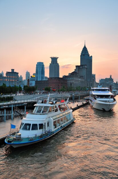Barca nel fiume Huangpu con l'architettura urbana di Shanghai al tramonto