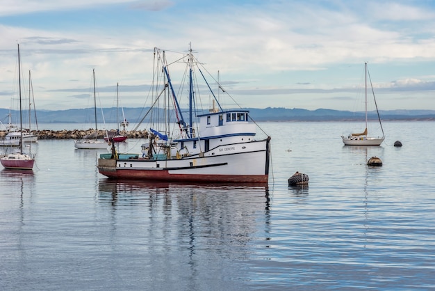 Barche a vela sull'acqua vicino al vecchio molo dei pescatori catturato a Monterey, Stati Uniti