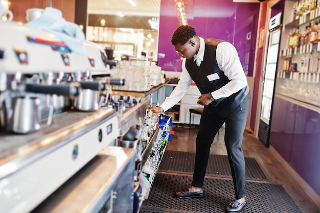 Barista afroamericano al bar che tiene bootle Preparazione di bevande alcolichexA