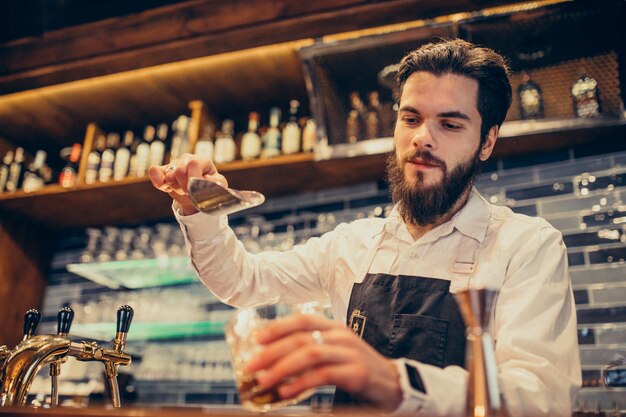 Barista bello che fa bere e cocktail ad un contatore