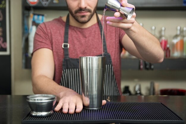 Barista che fa cocktail al bancone del bar