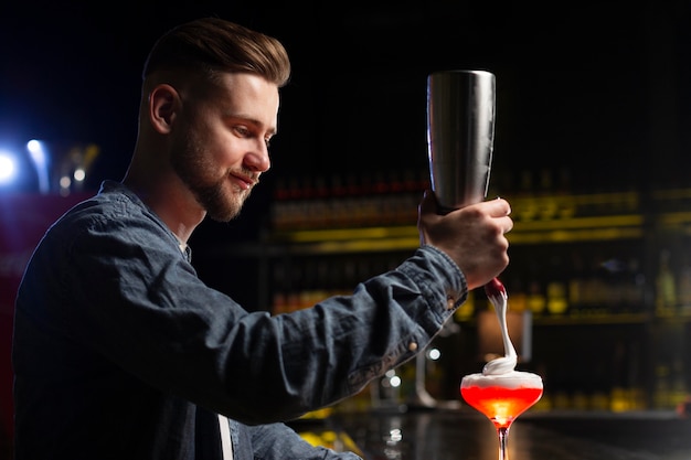 Barista che prepara un cocktail con uno shaker