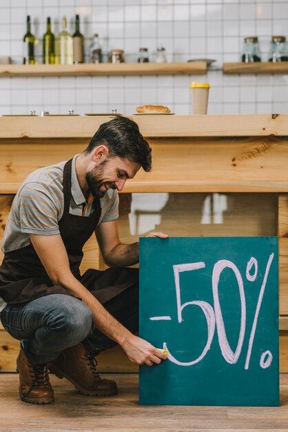 Barista che scrive annuncio di sconto