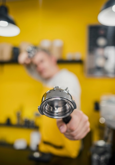 Barista Defocused che posa mentre tenendo tazza