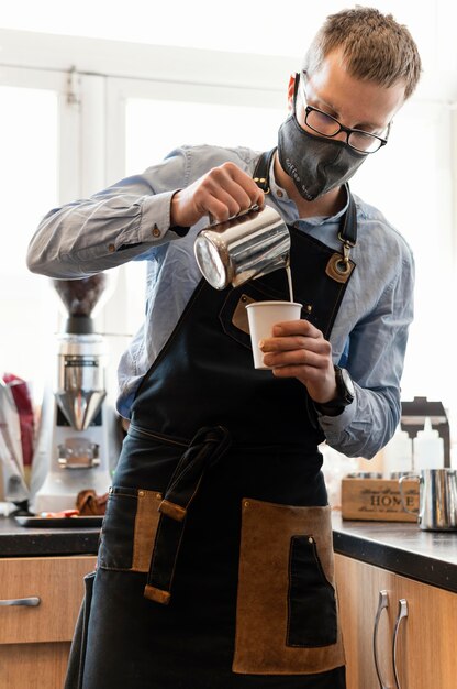 Barista di tiro medio che indossa la maschera