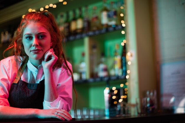 Barista femminile che si appoggia sul bancone del bar