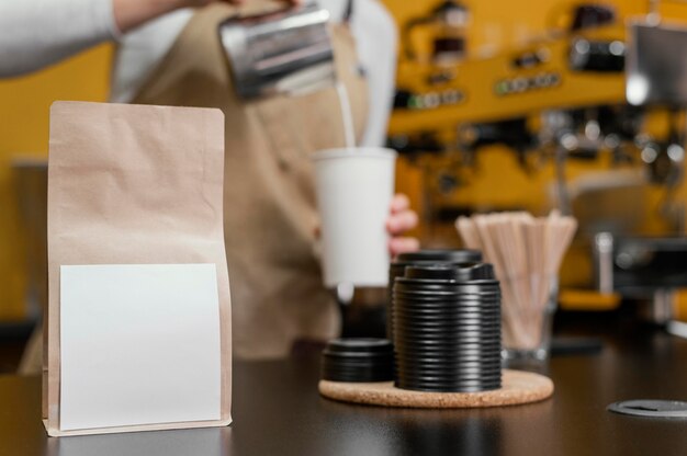 Barista femminile defocused che versa latte nella tazza di caffè