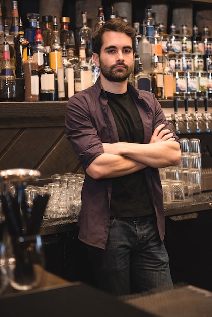 Barista fiducioso in piedi al bancone del bar