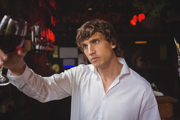 Barista guardando un bicchiere di vino rosso