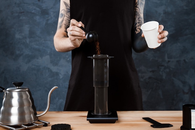 Barista maschio che prepara caffè. Aeropress metodo alternativo.