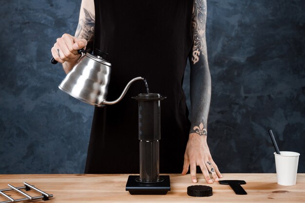 Barista maschio che prepara caffè. Aeropress metodo alternativo.