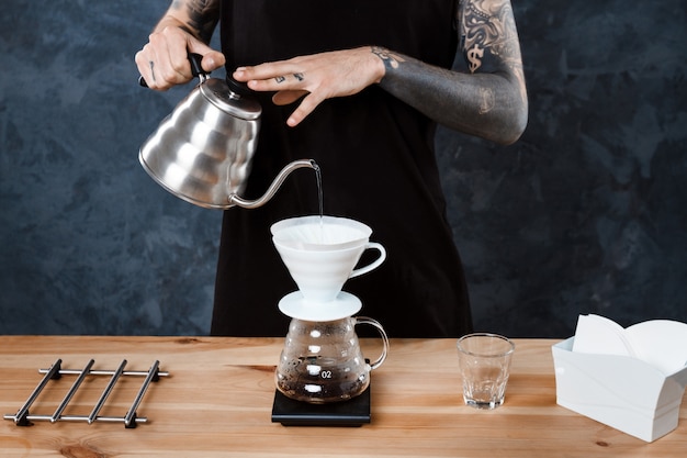 Barista maschio che prepara caffè. Metodo alternativo rovesciare.