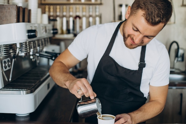 Barista maschio che prepara cappuccino in una caffetteria