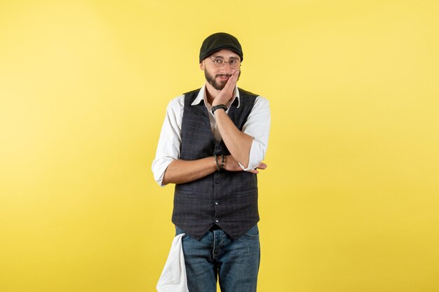 Barista maschio vista frontale in posa e guardando il modello di parete gialla bere lavoro club notte lavoro maschile