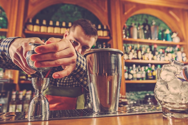 Barman che prepara un cocktail alcolico al bancone del bar