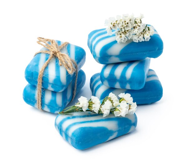 Barre di sapone naturale fatto a mano e fiori su sfondo bianco