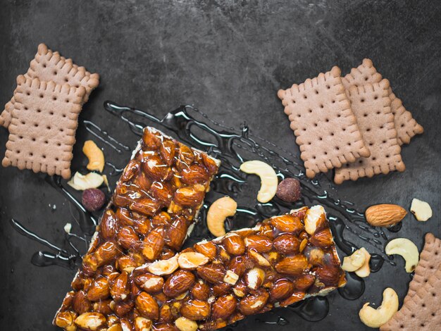 Barretta di frutta secca con biscotti su sfondo nero