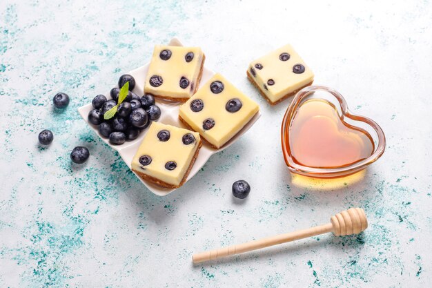 Barrette di cheesecake ai mirtilli con miele e frutti di bosco freschi