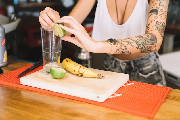 Bartender che fa cocktail con limone e banana