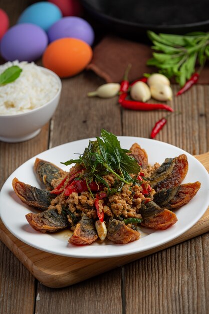 Basilico saltato in padella con uovo piccante del secolo servito con riso al vapore e salsa di pesce al peperoncino, cibo tailandese.