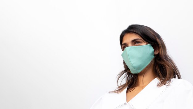 Basso angolo di donna con maschera facciale e copia spazio