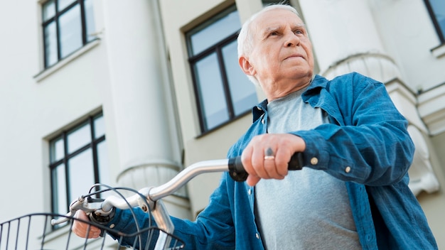 Basso angolo di vecchio con la bicicletta