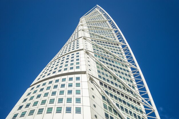 Basso angolo di visione del Turning Torso sotto un cielo blu e luce solare a Malmo in Svezia