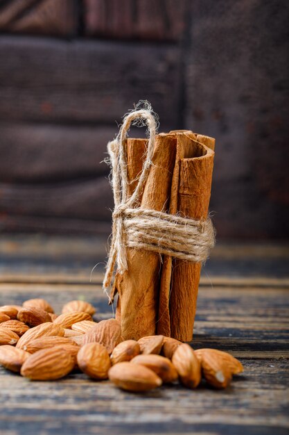 Bastoncini di cannella con mandorle su piastrelle di pietra e legno