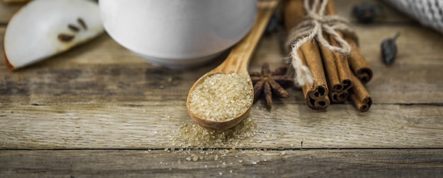 Bastoncini di cannella e un cucchiaio di zucchero di canna