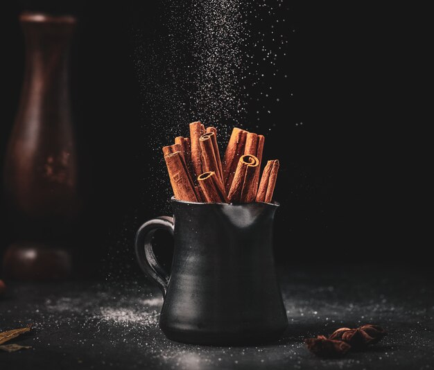 Bastoncini di cannella in tazza nera