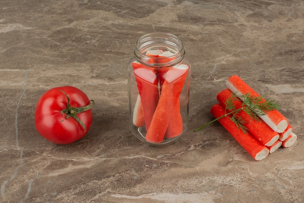 Bastoncini di granchio in vaso con pomodoro.