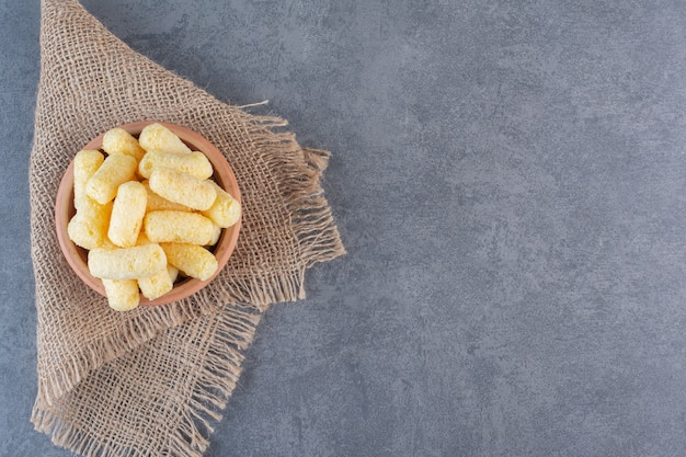 Bastoncini di mais dolce in una ciotola, sulla consistenza, sulla superficie di marmo