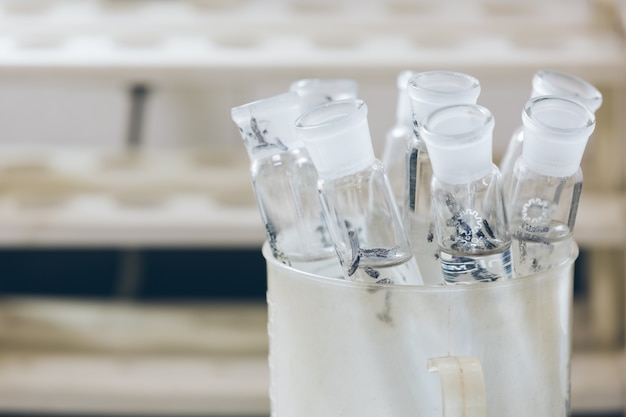 Beakers e attrezzature sul tavolo in laboratorio di fabbrica