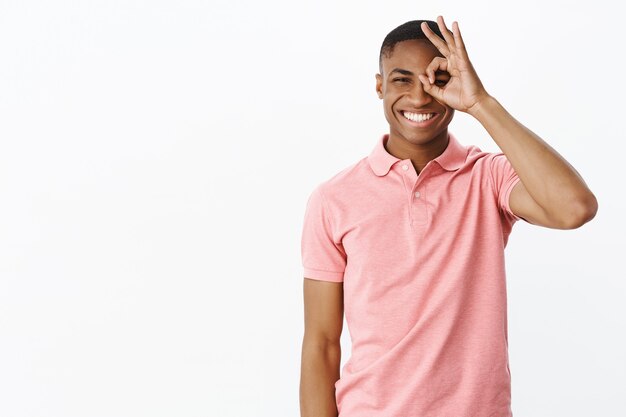 Bel giovane afro-americano con polo rosa Tshirt