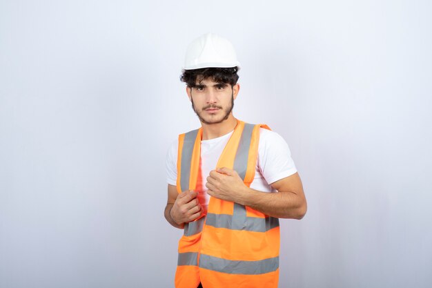 Bel giovane in uniforme in piedi sopra il muro bianco. Foto di alta qualità