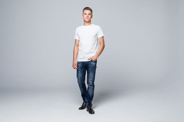 Bel giovane in uno stile casual abbigliamento bianco t-shirt e blue jeans su bianco