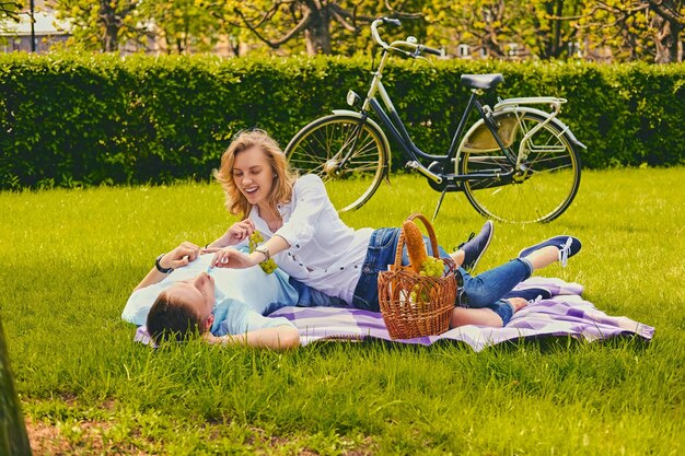 Bel giovane maschio e femmina bionda su un picnic in un parco estivo.