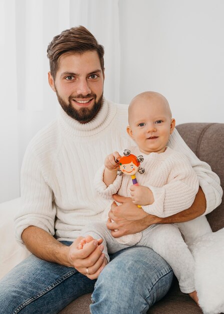 Bel padre in posa sul divano con il bambino