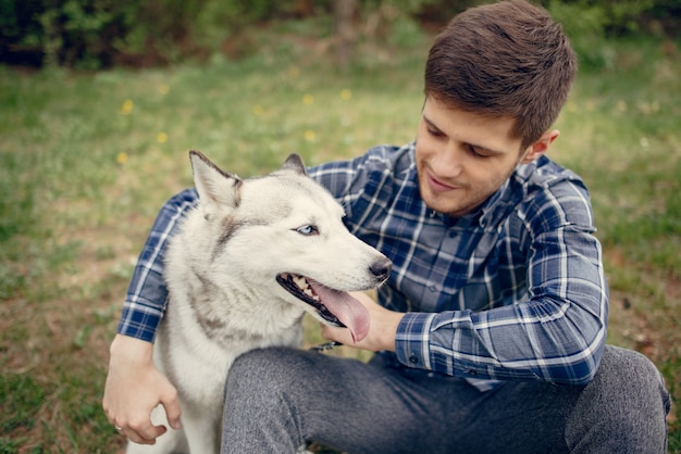 Bel ragazzo in un parco estivo con un cane