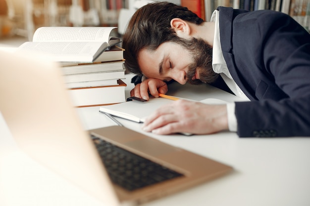 Bel ragazzo studia presso la biblioteca